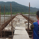 A Idu lady looks at the unfinished Dipu Nallah bridge, with Tezu on the other side.